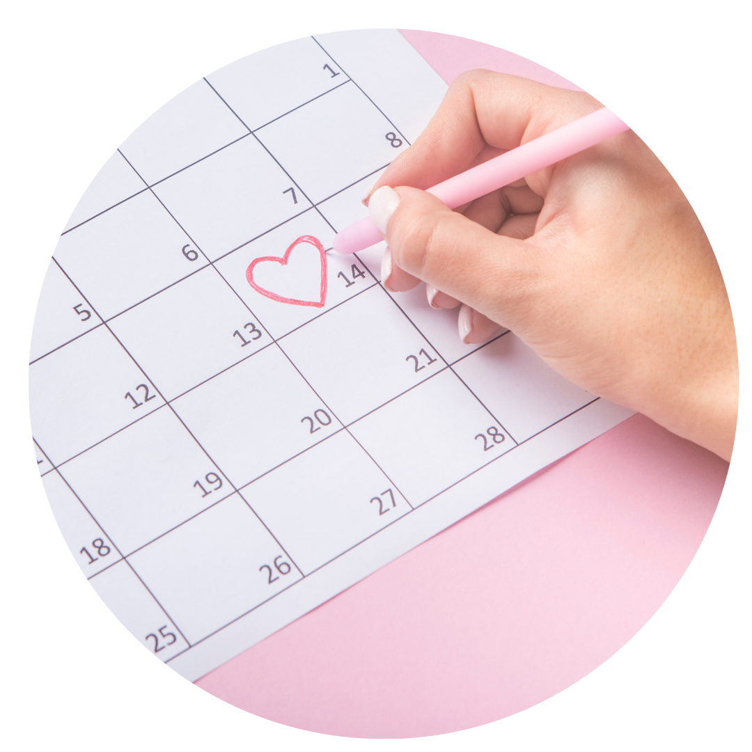 mão de mulher desenhando coração em um calendário.