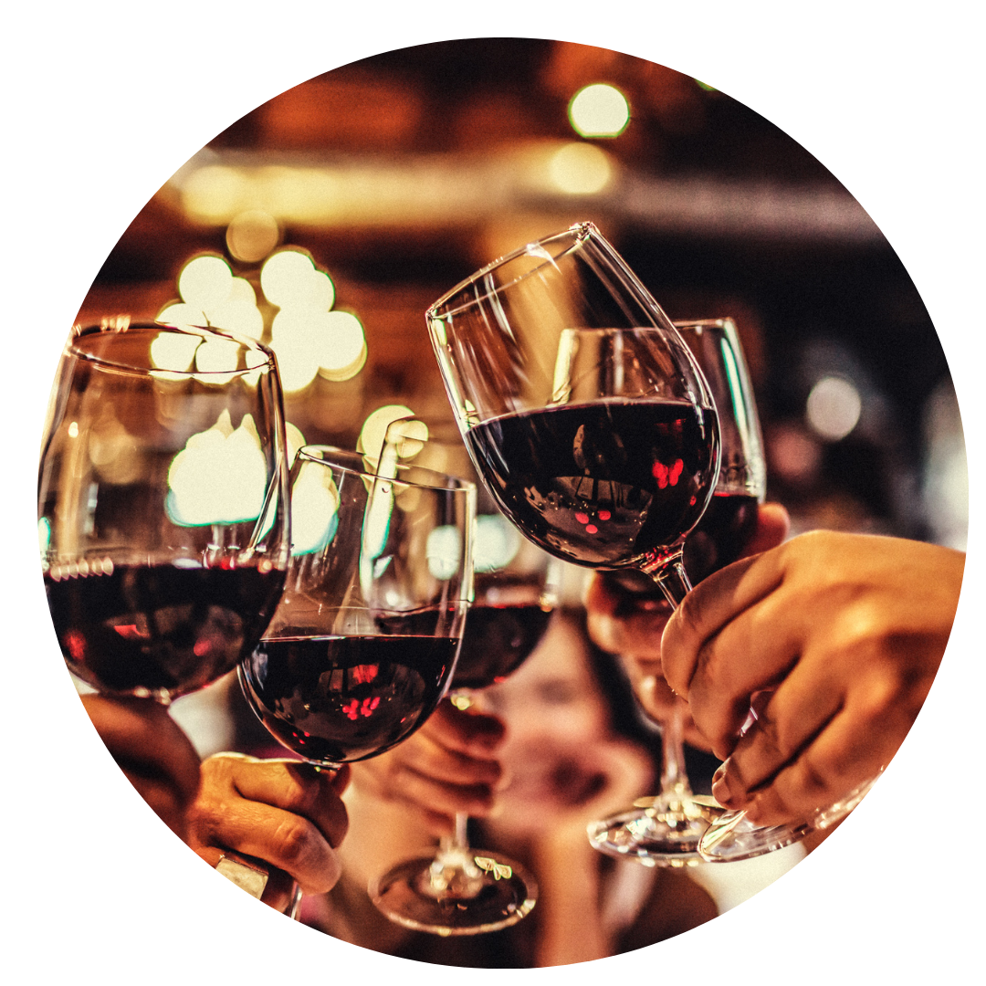 imagem de cinco pessoas segurando uma taças com vinho na mão fazendo um brinde. Foco da imagem nas mãos e nas taças.