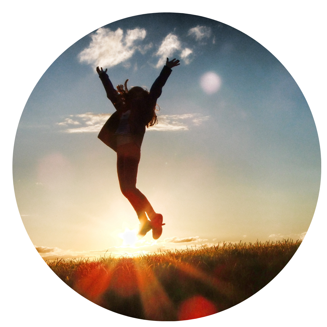 Silhueta de pessoa pulando em um final de tarde com o sol se pondo. Tem alguma nuvens no céu.